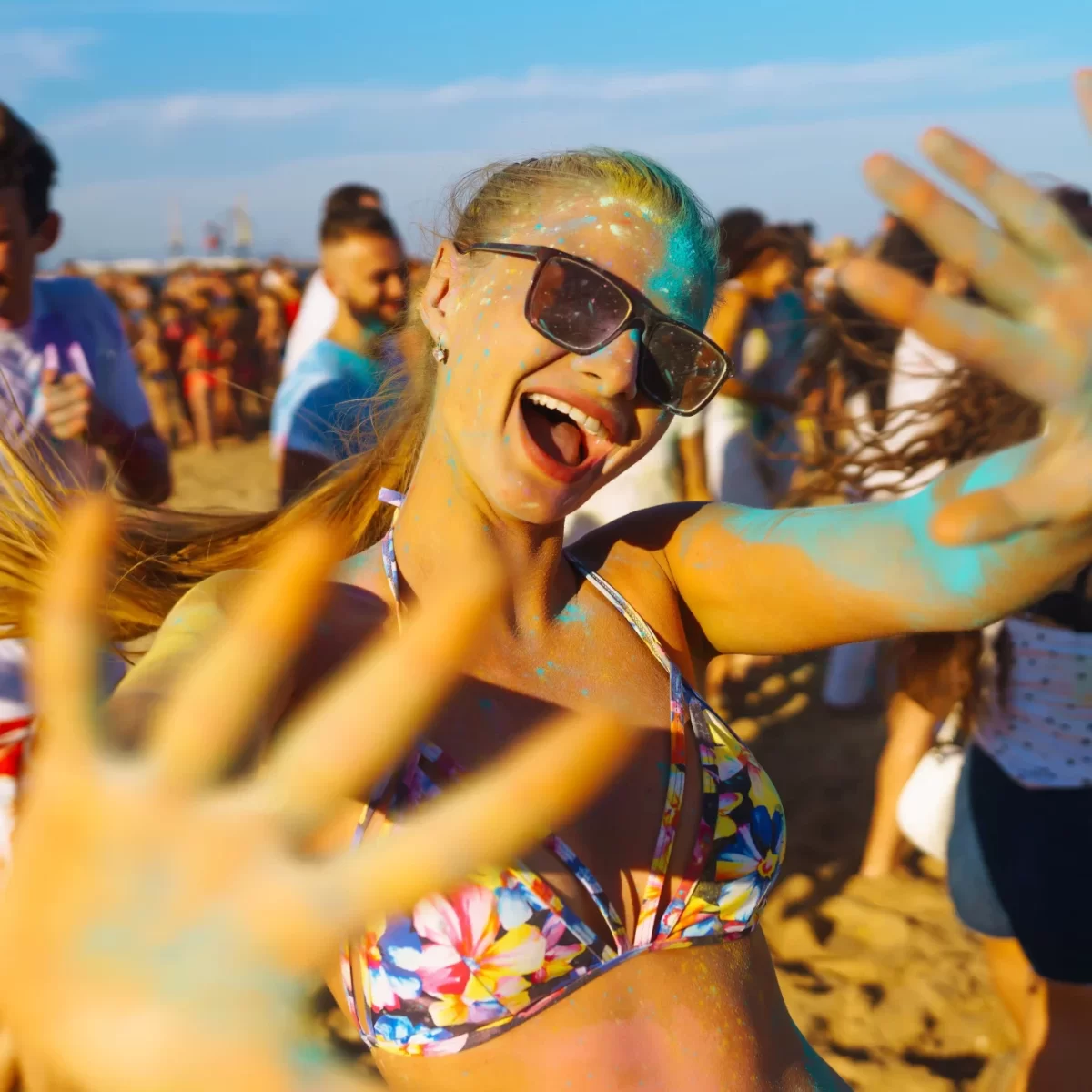 Giovani che si divertono colorandosi sulla spiaggia durante una festa estiva.