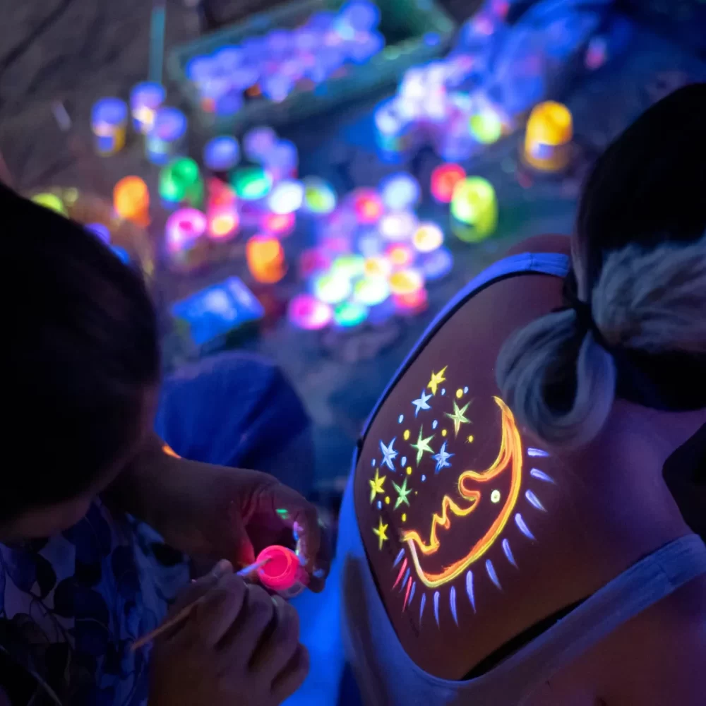 Tatuaggio luminoso di stelle e luna dipinto sulla schiena di una persona.