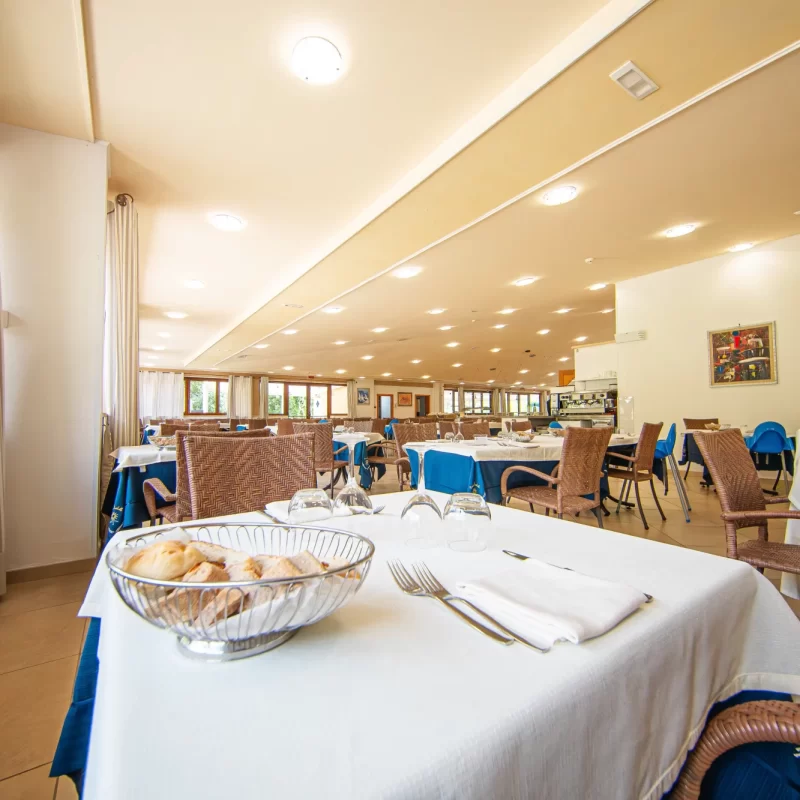 Ristorante elegante con tavoli apparecchiati e decorazioni blu.